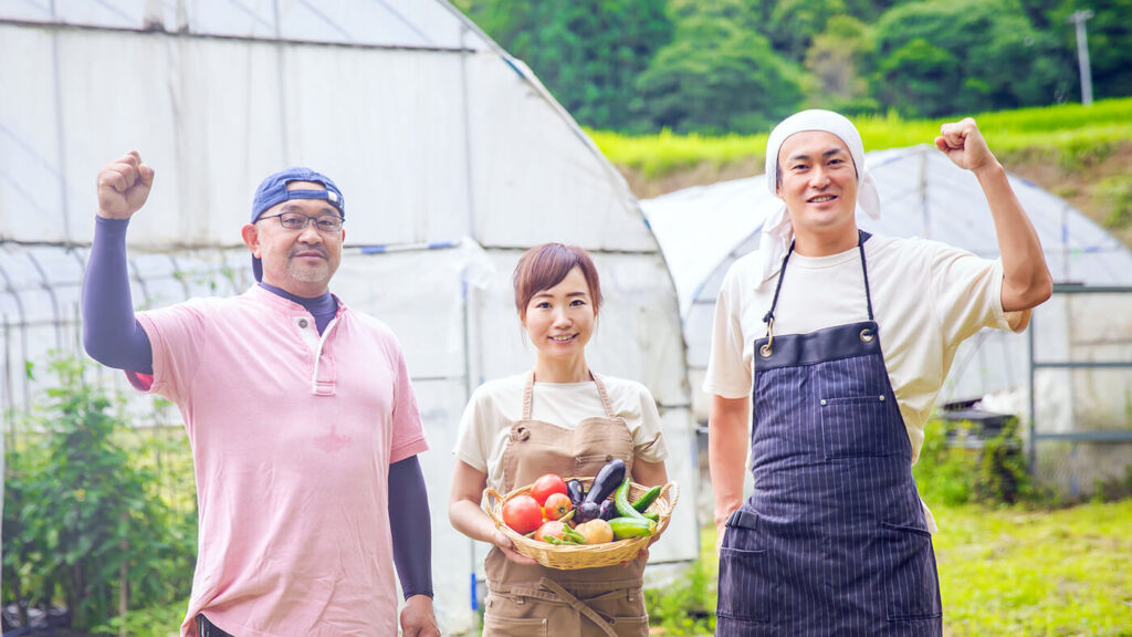 ポリシー1のイメージ写真_笑顔でとれたて野菜をもつ働く地元の人々